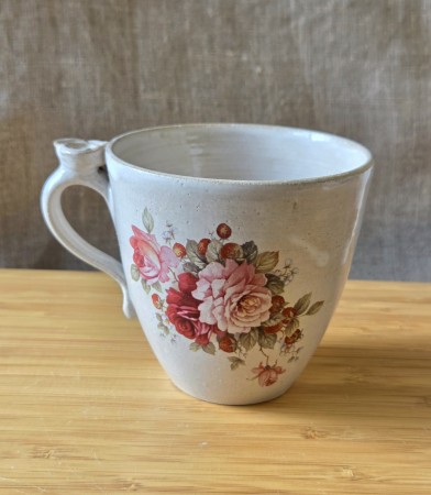 Kopp med roser og blomst på hanken